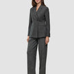 A woman wearing a Women Nara Blazer Fitted Black Check in charcoal gray plaid with matching wide-leg trousers.