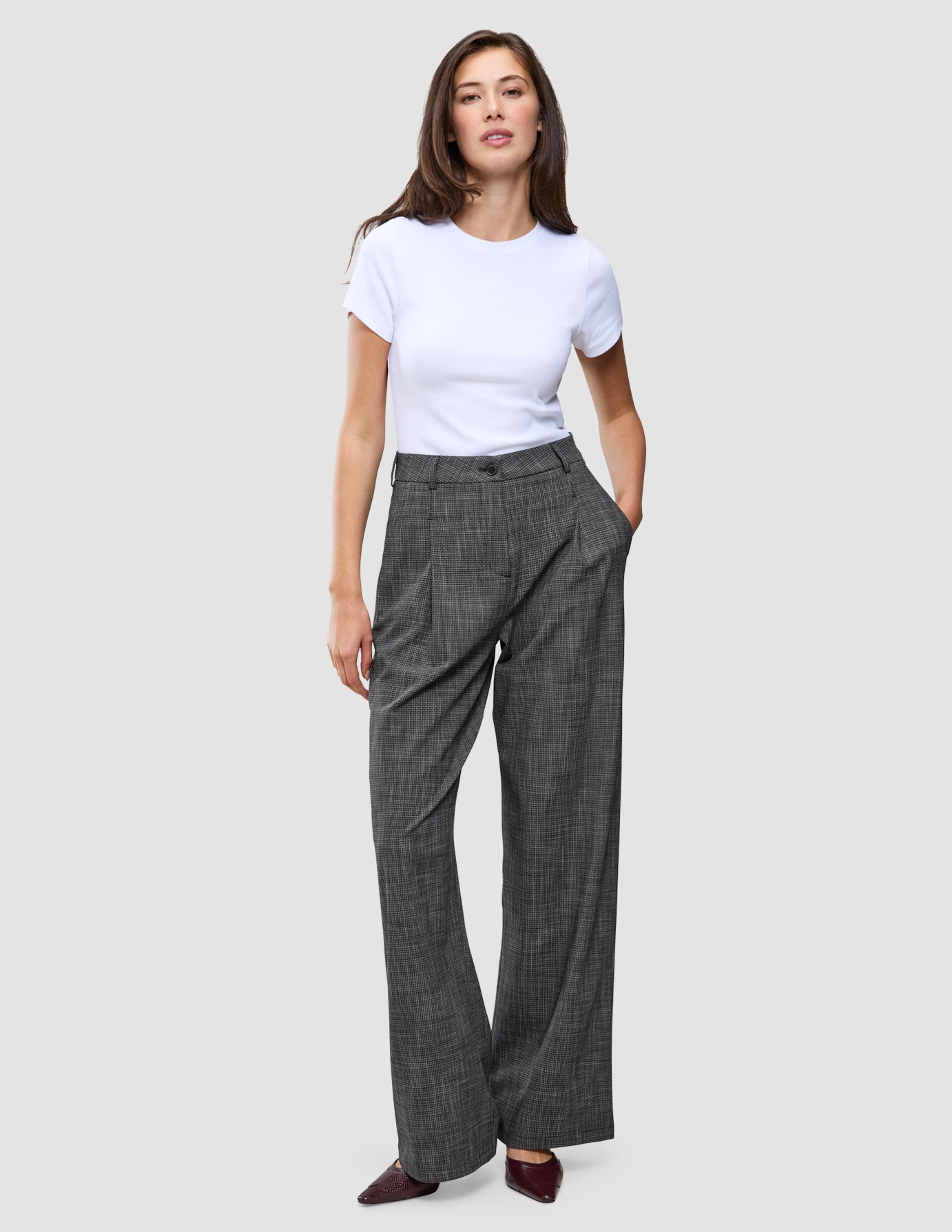 A woman wearing a white t-shirt and grey Women Nara Pants Wide Black Check with a subtle check pattern.