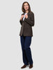 A person wears a Women Serene Blazer Regular Walnut Herringbone over a white t-shirt and blue jeans.