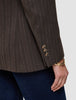 Close-up of a brown Women Serene Blazer Regular Walnut Herringbone featuring three buttons on the sleeve cuff, worn with dark denim jeans.