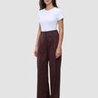A woman wears a white t-shirt tucked into Women Serene Pants Wide Berry Pinstripe.