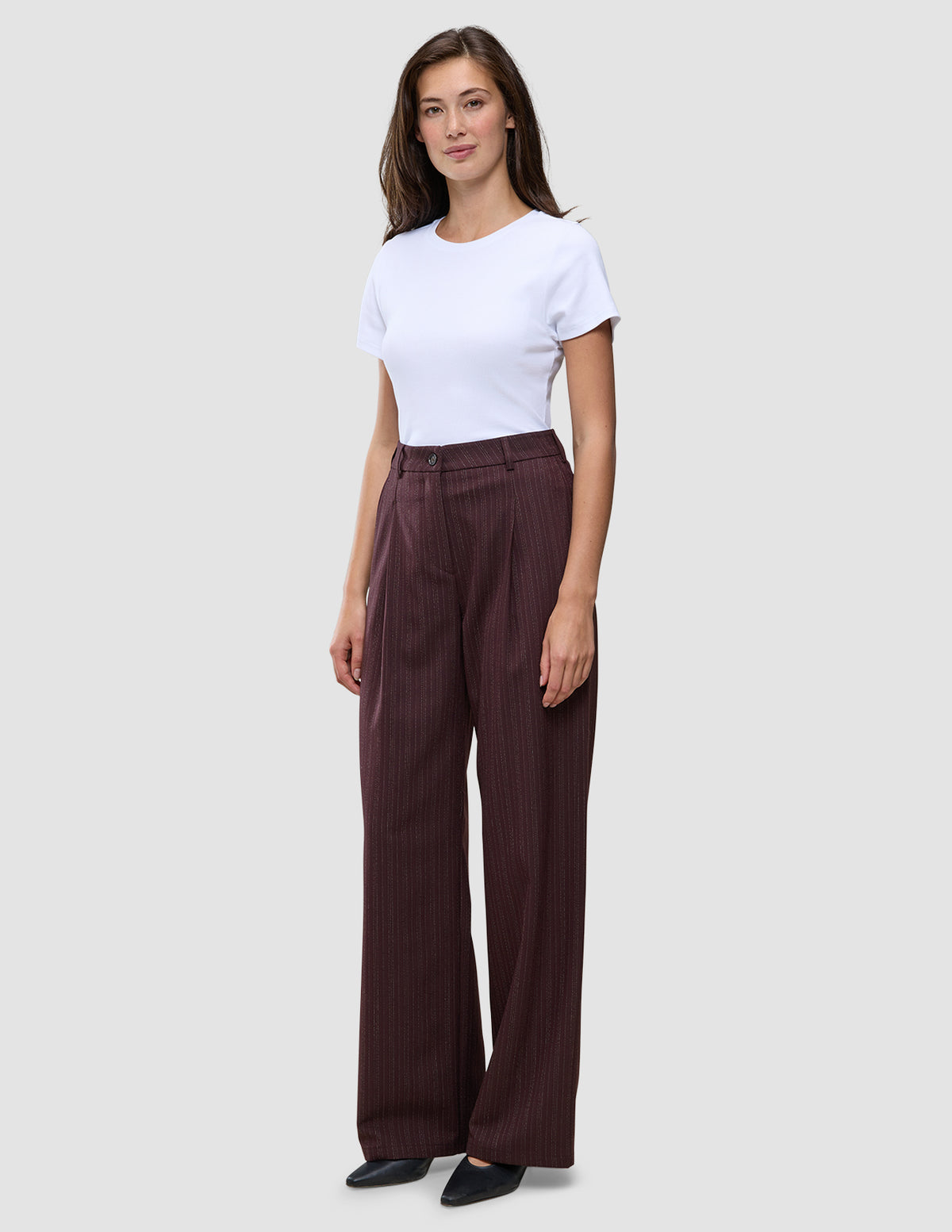 A woman wears a white t-shirt tucked into Women Serene Pants Wide Berry Pinstripe.