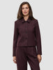 A woman wears the Women Serene Short Jacket Berry Pinstripe, a berry-colored, button-front short jacket in a Scandinavian design with thin vertical pinstripes.