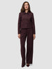 A woman wearing a Women Serene Short Jacket Berry Pinstripe with matching wide-leg trousers in a Scandinavian design.