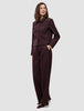 A woman wears a Women Serene Short Jacket Berry Pinstripe in a dark berry-colored Scandinavian design, paired with matching wide-leg trousers.