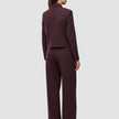 A person seen from behind wears the Women Serene Short Jacket Berry Pinstripe and matching wide-leg trousers in a Scandinavian design.